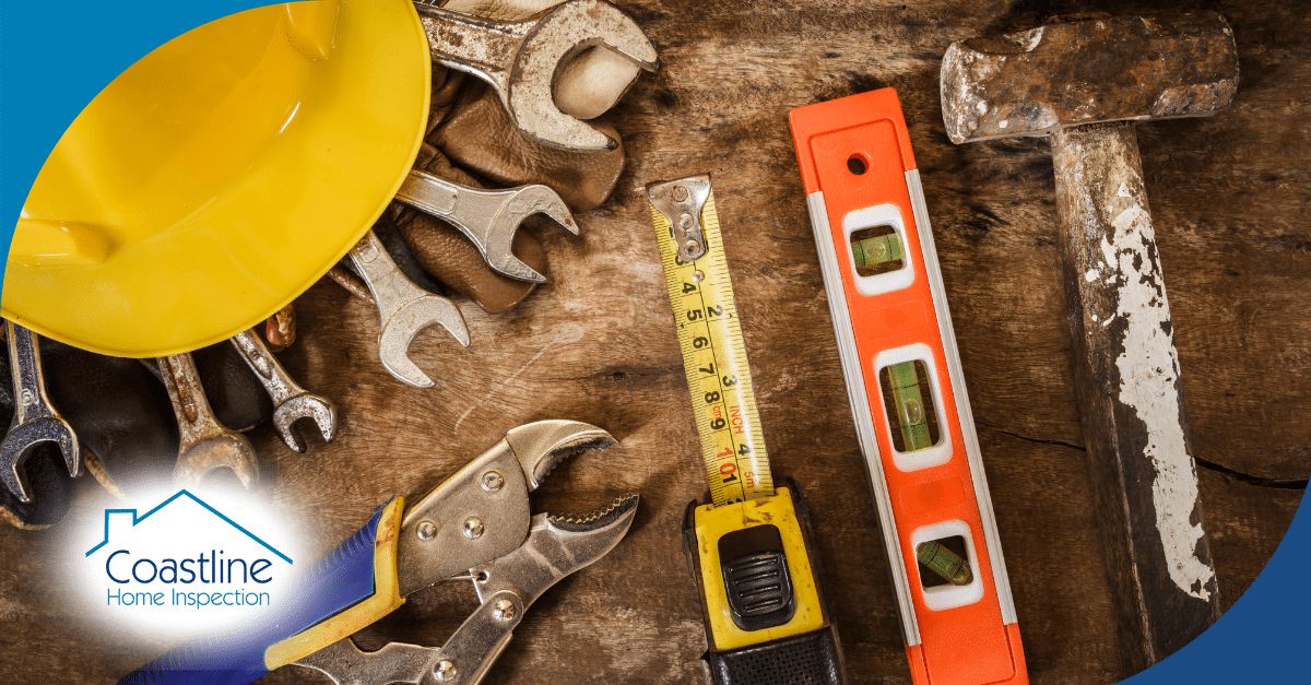 Home inspection tools including a tape measure, level, and worn hammer on a wooden surface.